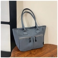 Dettaglio borsa tote in nylon grigio con doppie tasche a cerniera su tavolo di legno - Grigio