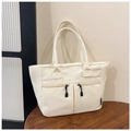 Dettaglio della borsa tote in nylon bianco crema con due tasche a zip su un tavolo di legno - Bianco Sporco