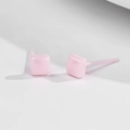 Detailansicht der glänzenden quadratischen Keramik-Ohrstecker in Rosa auf grauem Grund - Quadratisch / Rosa