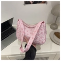 Gros plan détaillé du sac à main rose matelassé avec motifs de nœuds et fermeture éclair - Rose