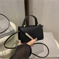 Mini-Umhängetasche in Schwarz mit goldener Metallverzierung und elegantem Handgriff - Schwarz