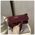 Sleek wine red patent leather baguette bag with a minimalist shoulder strap design - Red