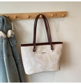 Detalle de un bolso tote beige con textura de mármol y logo JINGPIN en percha de madera - Beige
