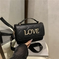 Black quilted crossbody bag with gold metal LOVE lettering and crystal inlay on flap - Black