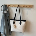 Minimale cremeweiße PU-Leder-Einkaufstasche mit schwarzen Trägern und Plüsch-Anhänger - Gebrochenes Weiß