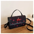 Close-up of black cherry print crossbody bag with 3D cherry decoration on wood table - Black