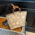 Borsa tote jacquard vintage con fiori e manici in bambù su panca di legno - Beige