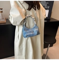 Detailansicht der blauen Denim-Beuteltasche mit silbernen Schmetterlingen und Griff - Blau