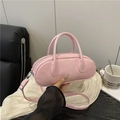 Pink bowling style leather handbag with smooth glossy finish and matching long strap - Pink
