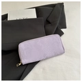 Close-up of lavender snake-embossed leather wallet with gold zipper on a black suit - Purple