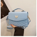 Hellblaue Handtasche aus Kunstleder mit goldener Schmetterlingsschließe und V-Steppung - Blau