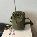 Detalle de bandolera de nailon verde militar con bolsillo de cordón y correa ancha - Verde