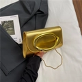 Bolso bandolera dorado metalizado con asa ovalada y cadena sobre tela blanca - Dorado
