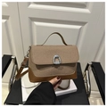 Close-up of retro color-block handbag with woven texture and horseshoe metal buckle - Brown