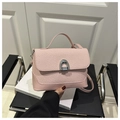Detail of pink woven leather handbag with signature silver horseshoe metal buckle closure - Pink
