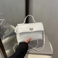 Sac bandoulière blanc minimaliste avec fermoir doré et design texturé sur un livre - Blanc