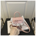 Close-up of pink patent leather bag with white lace trim and bow accent detail - Pink