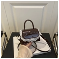 Detail of caramel brown mini handbag featuring lace trim and a central bow accent - Brown