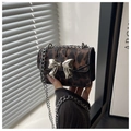 Nahaufnahme der Mini-Tasche mit Leopardenmuster, silberner Schleifenschnalle und Kette - Braun