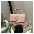 Detail der hellrosa Handtasche aus Leder mit Metallschließe und rundem Tragegriff - Rosa