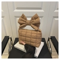 Detail of puffy quilted shoulder bag in brown with stylish bow handle and zip closure - Khaki