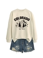 Flat lay of beige Colorado graphic sweatshirt paired with distressed denim shorts - Sand (Black Print)