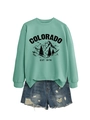 Flat lay of a mint green sweatshirt with Colorado print and distressed denim shorts - Light Green (Black Print)