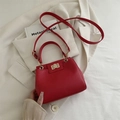 Red lychee pattern crossbody bag with a gold metal turn-lock and elegant top handle - Red