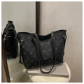 Black tote bag with lychee texture and cartoon rabbit print on a white stool - Black