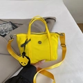 Bright yellow nylon mini tote bag with crossbody strap and panda charm accessory - Yellow