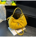 Yellow suede hobo bag with bow decoration and heart pendant on a white magazine background - Yellow