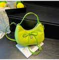 Neon green suede handbag with a bow detail and heart charm in a stylish setting - Green