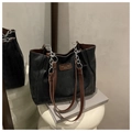 Dettaglio della trama trapuntata e catena argentata sulla borsa shopper nera - Marrone