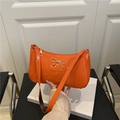Orange patent leather baguette shoulder bag featuring a golden metallic bow detail - Orange