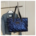 Detail der gesteppten metallisch blauen Shopper-Tasche mit Markenlabel und Tragegriffen - Silber