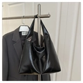 Détail du sac cabas en cuir noir brillant avec une silhouette minimaliste élégante - Style Brillant / Noir