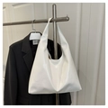 Sac hobo blanc minimaliste en similicuir brillant exposé sur un cintre en métal - Style Brillant / Blanc