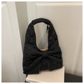 Detail einer schwarzen Stepptasche mit großer Schleife und glänzender Nylonstruktur - Schwarz