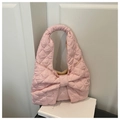 Detailansicht der rosa gesteppten Nylon-Handtasche mit großer Schleife auf weißen Büchern - Rosa