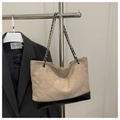 Detalle del bolso tote acolchado de ante beige y cuero negro con cadena dorada - Caqui