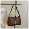 Detail of dark brown leather underarm bag with unique gold artistic metal buckle closure - Brown