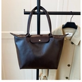 Detalle del bolso tote marrón oscuro con textura de cuero y hebilla metálica clásica - Marrón