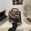 Retro argyle pattern backpack purse with top handle and adjustable straps on white desk - Green