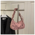 Detailed shot of pink corduroy shoulder bag with black bows and ruffled strap design - Pink