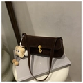 Detail of dark brown suede underarm bag featuring an oval gold buckle and plush charm - With Pendant / Brown