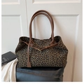 Dettaglio della borsa tote leopardata con manici in pelle marrone e cinturini laterali - Verde