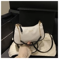 Close-up of crescent bag with golden chain in luxury gift box with silk lining - White