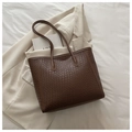 Detail einer großen braunen Shopper-Tasche mit Flechtmuster in minimalistischem Stil - Dunkelbraun