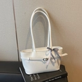 White leather tote bag with stylish belt buckle and checkered bow on a design book - Off White