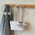White leather tote bag with decorative buckle and plaid scarf on a wooden hook - Off White